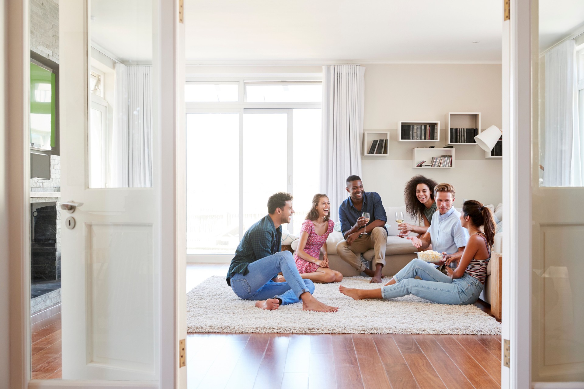 Group Of Friends Relaxing At Home And Drinking Wine Together